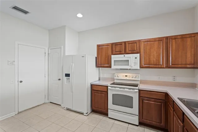 a kitchen with white cabinets and white appliances