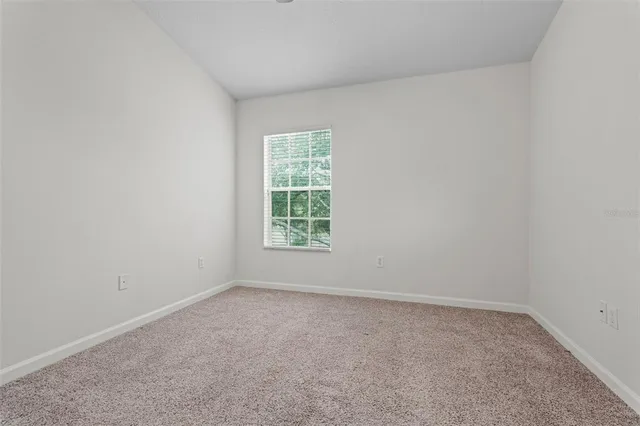 an empty room with chandelier fan
