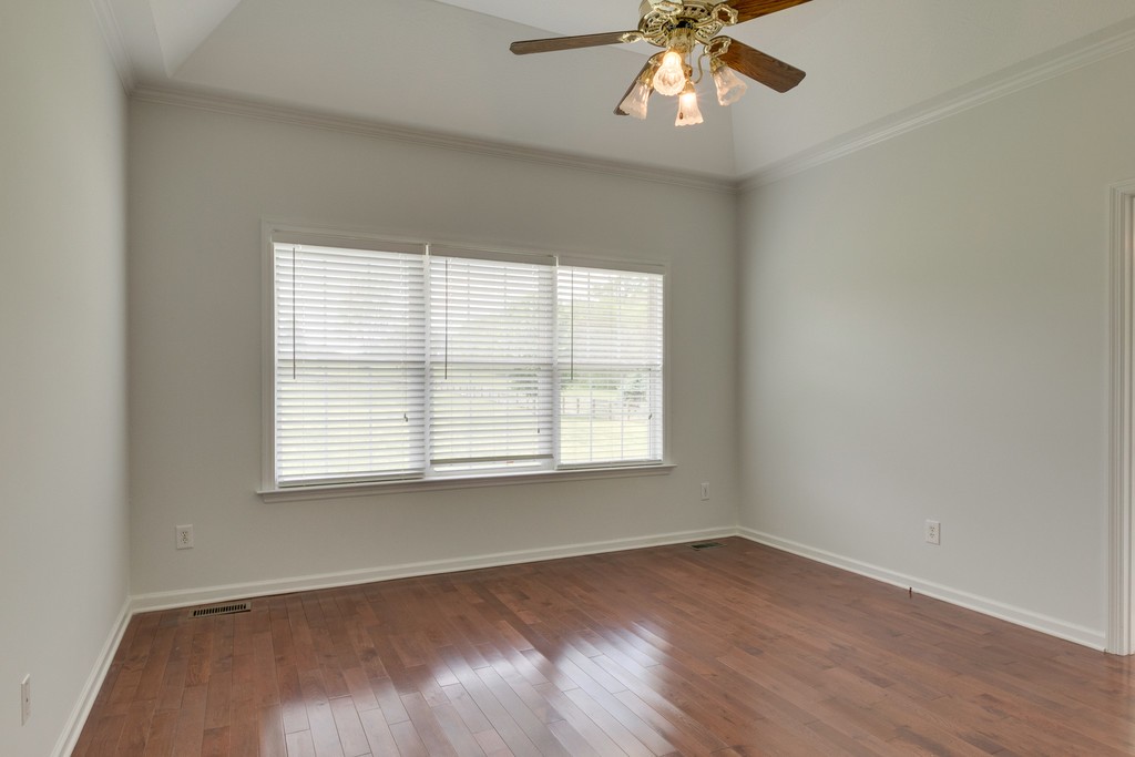 3501 Greens Mill Road Spring Hill, TN 37174 - Photo 8 of 16 an empty room with wooden floor chandelier fan and windows