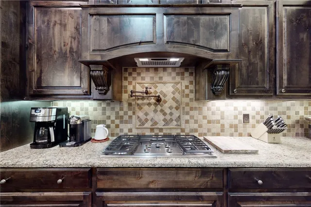 a kitchen with granite countertop a stove a cabinets and a counter top space