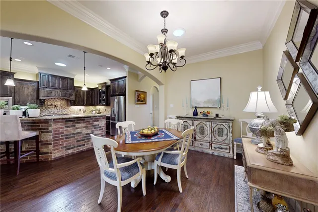 a dining room with furniture a chandelier and wooden floor