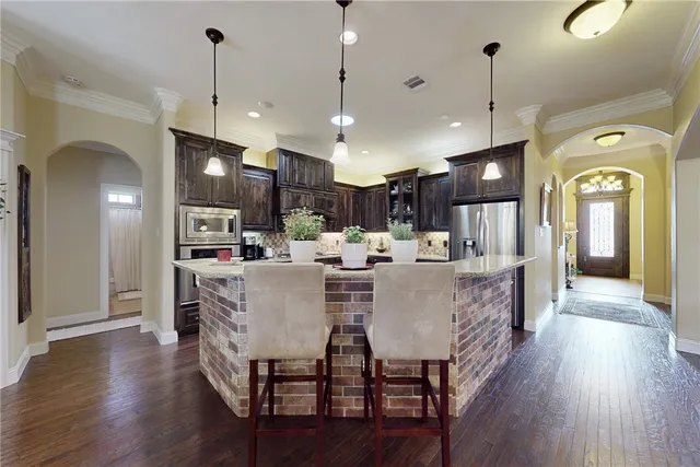 a view of a dining room and livingroom with furniture wooden floor a chandelier