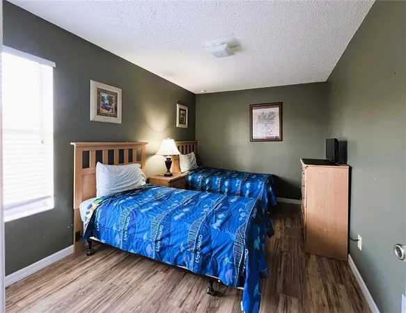 a bedroom with two beds and a painting on the wall