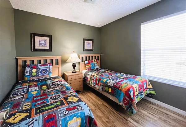a bedroom with two beds and wooden floor