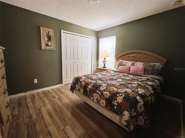 a bedroom with bed and wooden floor