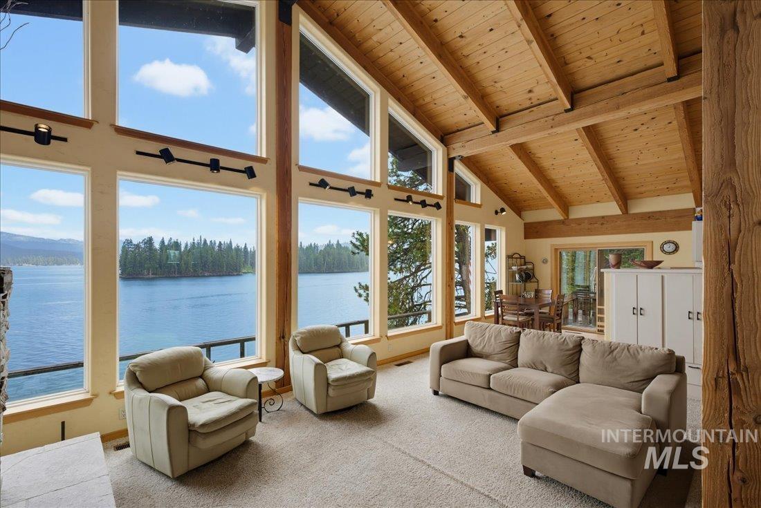 3800 Warren Wagon Road McCall, ID 83638 - Photo 6 of 50 Vaulted ceilings with exposed wood beams, expansive floor-to-ceiling windows, wood-finish flooring, and built-in cabinetry