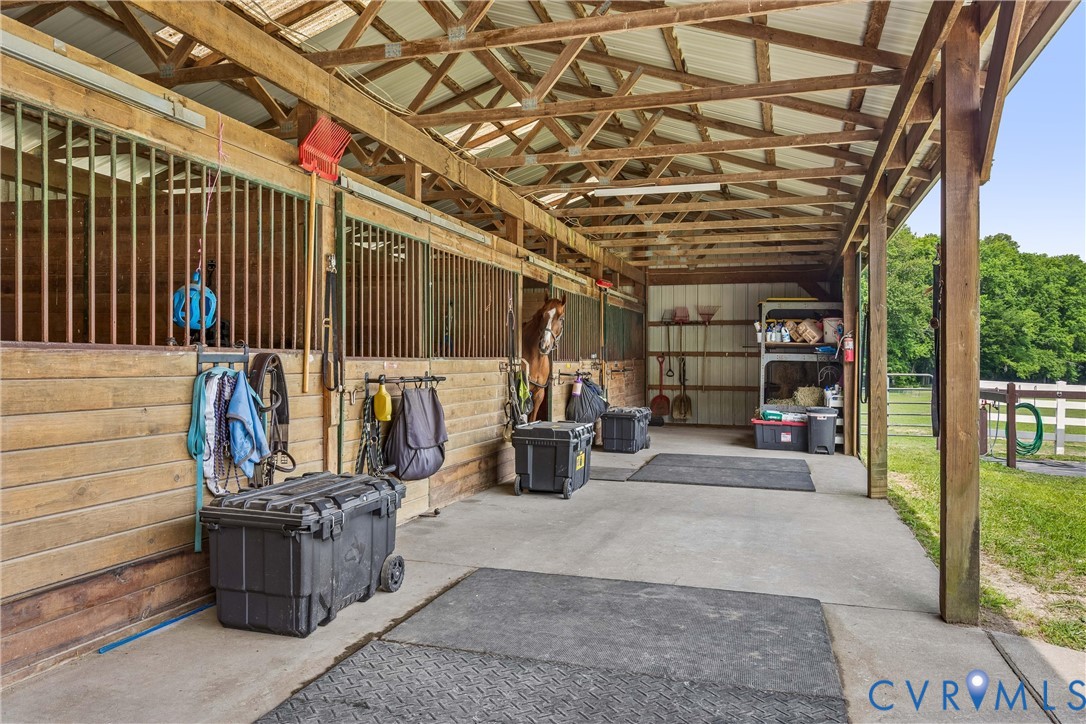2016 Forge Road Toano, VA 23168 - Photo 34 of 99 Covered barn aisle featuring wood-paneled stalls w
