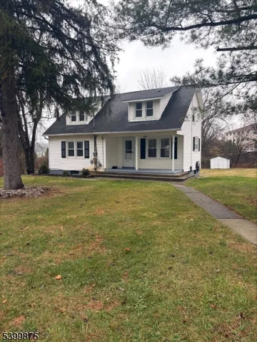 a front view of a house with a garden and trees