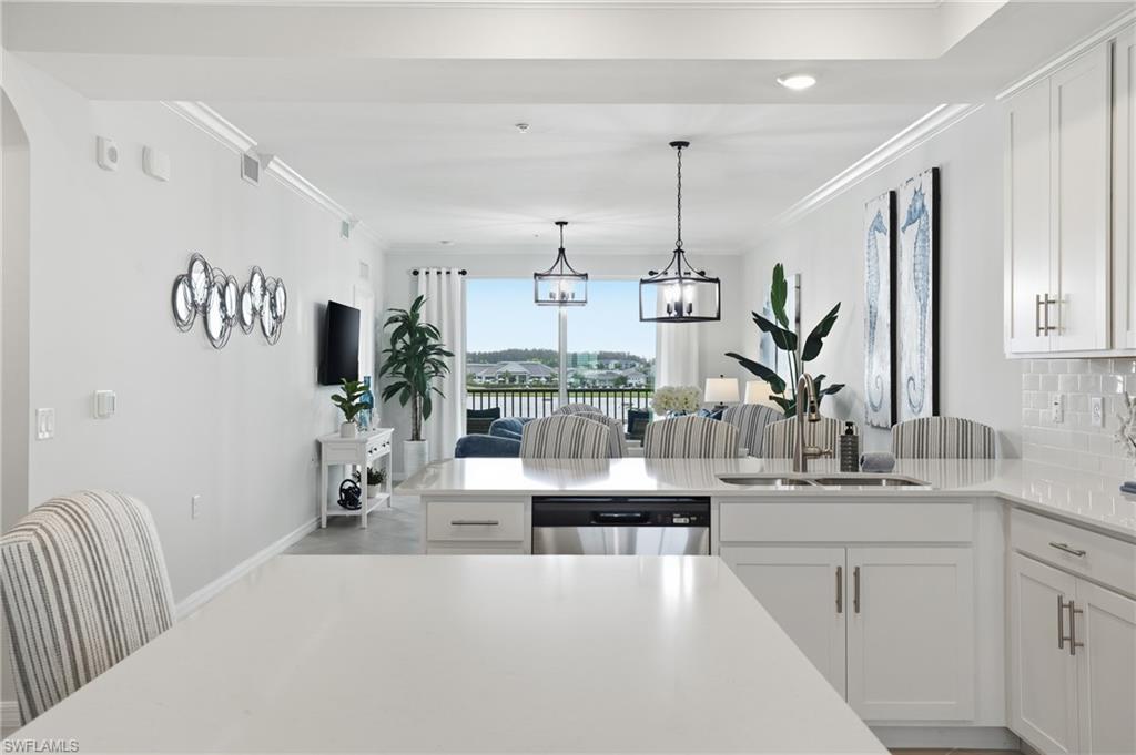5555 Double Eagle Circle, Unit 3935 Ave Maria, FL 34142 - Photo 12 of 49 a kitchen with kitchen island a counter top space and a sink