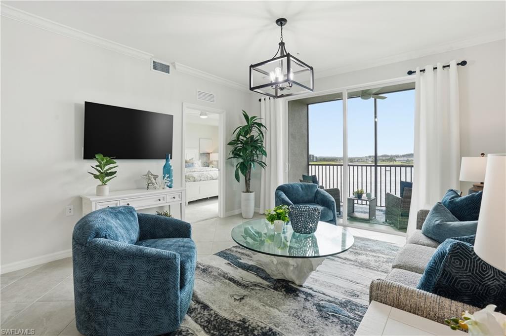 5555 Double Eagle Circle, Unit 3935 Ave Maria, FL 34142 - Photo 4 of 49 a living room with furniture a chandelier and a flat screen tv