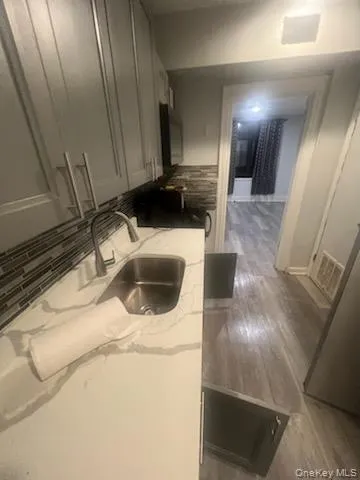 a view of a refrigerator in kitchen and an empty room