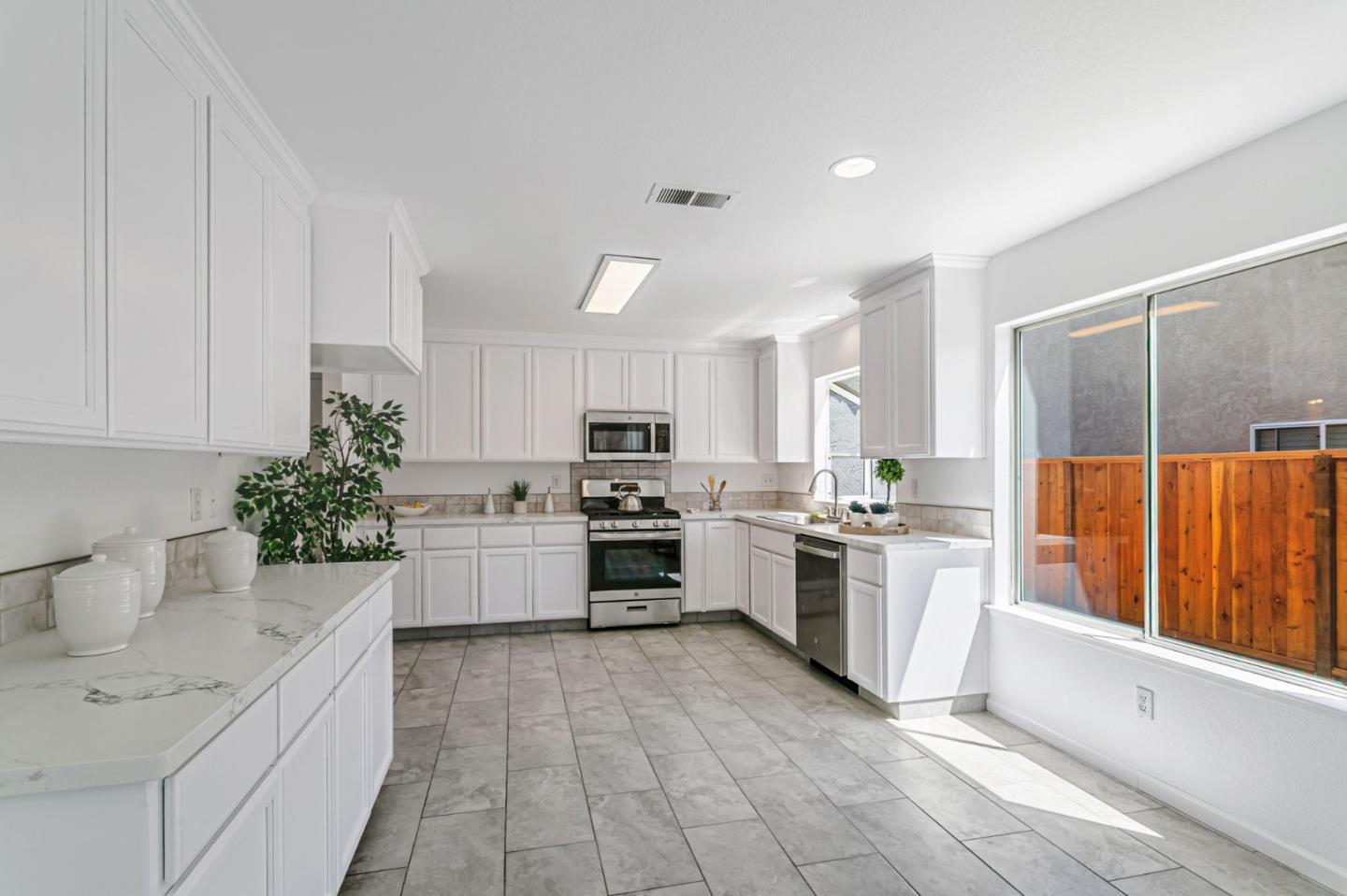 770 Babbs Creek Drive Gilroy, CA 95020 - Photo 10 of 39 a large kitchen with a sink and dishwasher a stove top oven with wooden floor