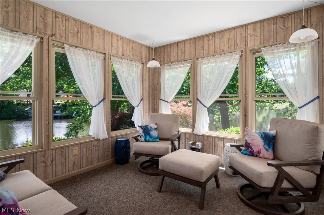 685 Sunnyside Road Vermilion, OH 44089 - Photo 28 of 50 Sunroom featuring extensive window-lined walls, wood-paneled walls, and a recessed ceiling with pendant lighting