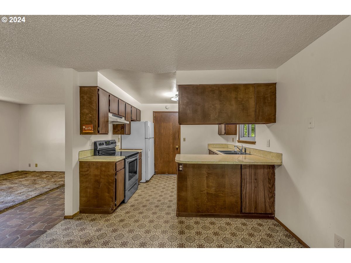 69711 Marcott Road Rainier, OR 97048 - Photo 7 of 18 a kitchen with stainless steel appliances a sink a stove top oven a counter space and cabinets