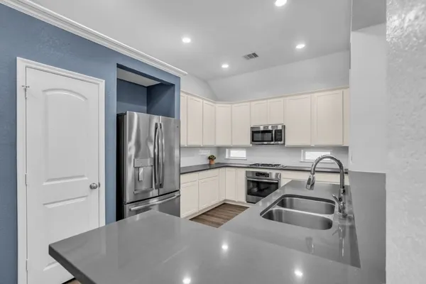 a kitchen with stainless steel appliances a refrigerator sink and microwave