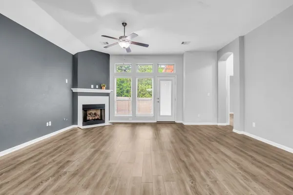 a view of an empty room with a fireplace and a window