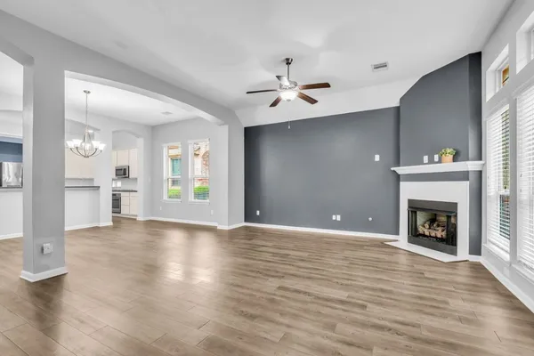 a view of an empty room with a fireplace and a window