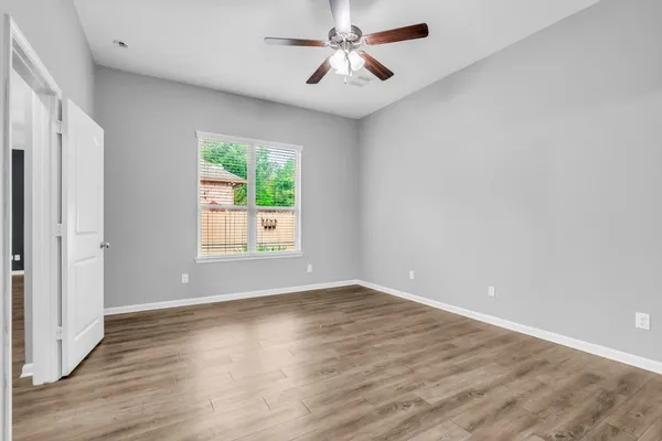 an empty room with wooden floor and windows