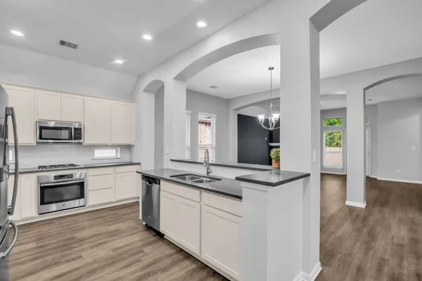 a kitchen with stainless steel appliances granite countertop a stove a sink and a refrigerator