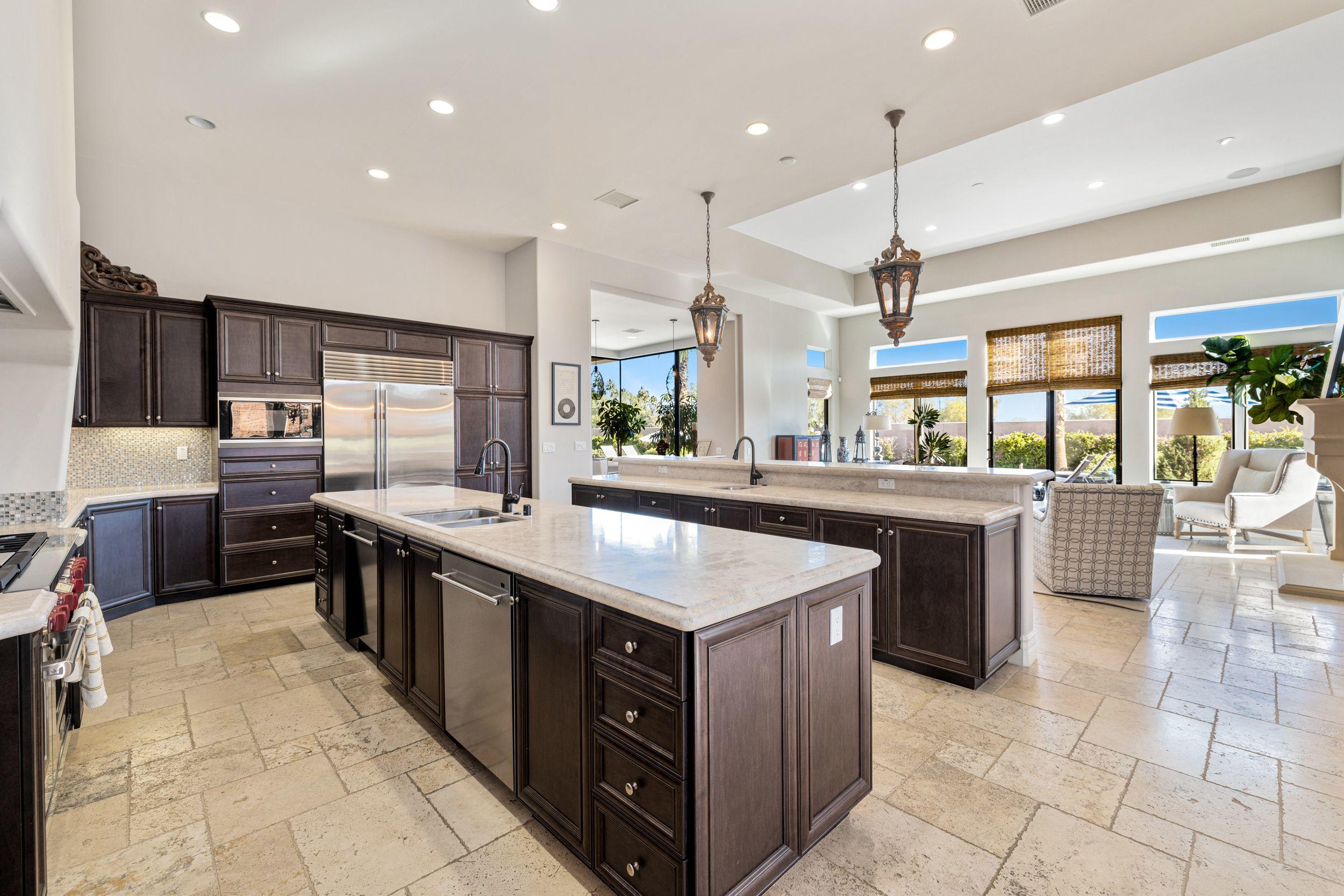 54360 Alysheba Drive La Quinta, CA 92253 - Photo 8 of 24 a kitchen with a stove a sink a counter top space and living room view
