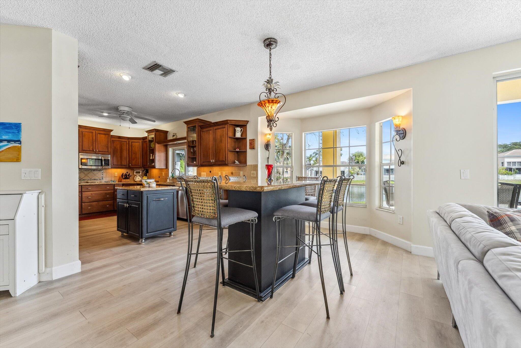 640 Culpepper Terrace Davie, FL 33325 - Photo 16 of 68 a view of a dining room and livingroom with furniture wooden floor a rug a flat screen tv