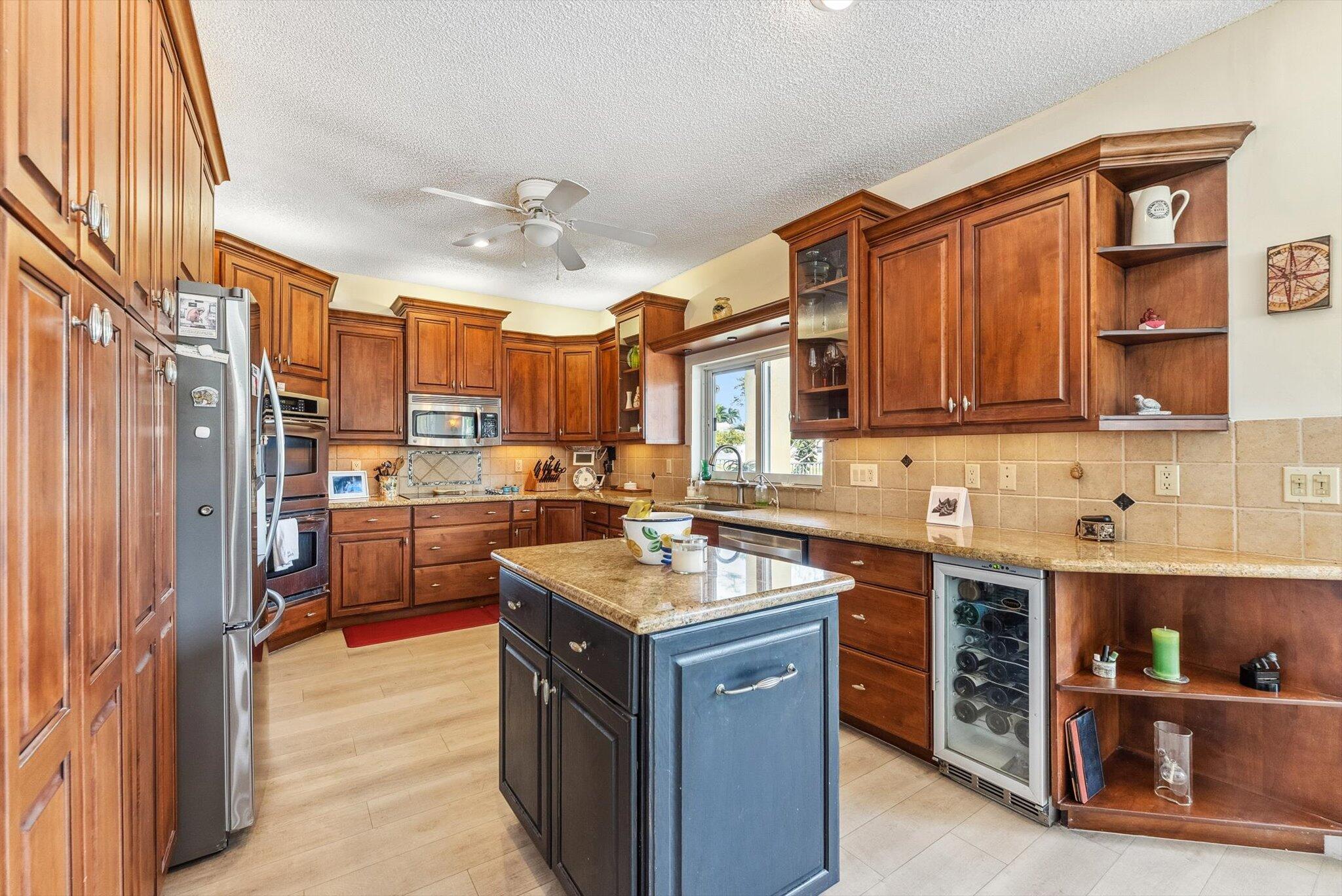 640 Culpepper Terrace Davie, FL 33325 - Photo 18 of 68 a kitchen with stainless steel appliances granite countertop a stove refrigerator and a sink