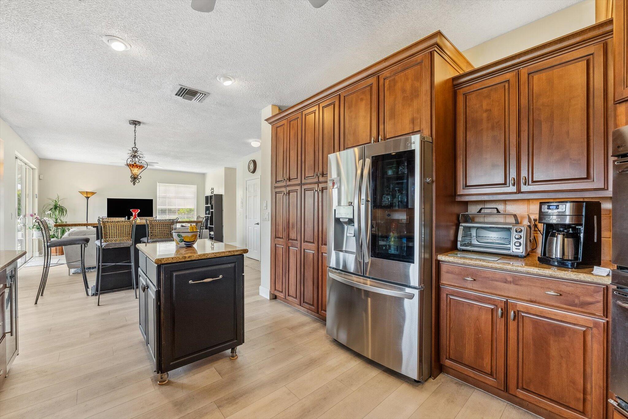 640 Culpepper Terrace Davie, FL 33325 - Photo 19 of 68 a kitchen with stainless steel appliances kitchen island granite countertop a refrigerator and cabinets
