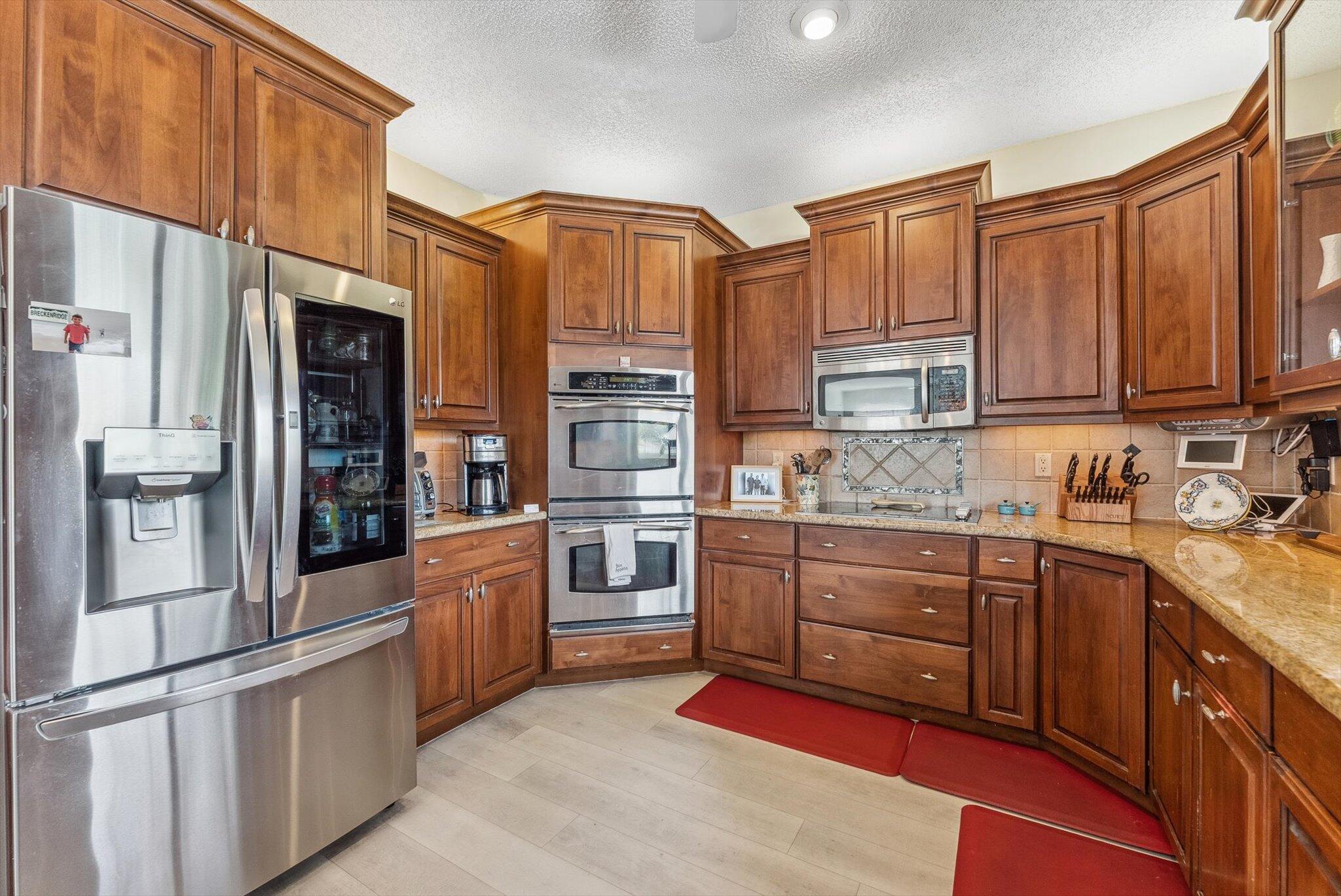 640 Culpepper Terrace Davie, FL 33325 - Photo 21 of 68 a kitchen with stainless steel appliances granite countertop a refrigerator a stove and a sink with wooden cabinets