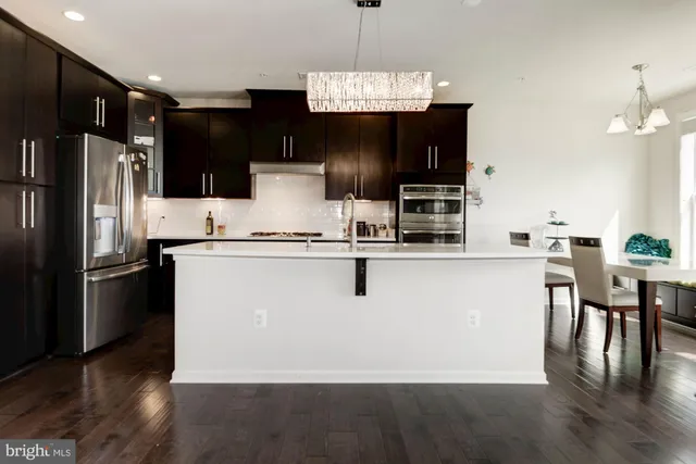 a kitchen with kitchen island a counter top space stainless steel appliances and cabinets