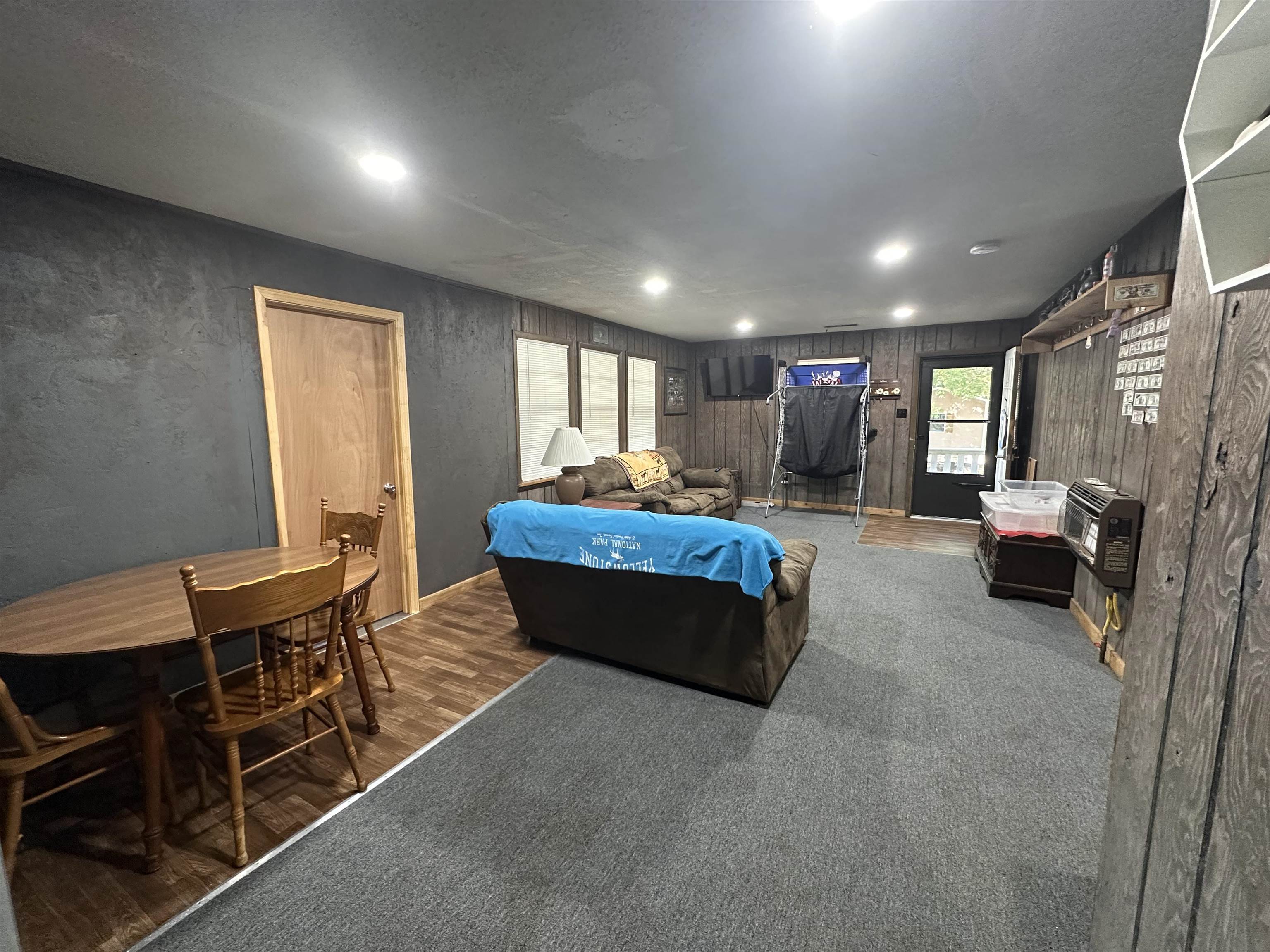 481 Chisholm Lake Camp Road Ripley, TN 38063 - Photo 11 of 12 Spacious room featuring recessed ceiling lights, dark-toned textured wall treatment, and mixed flooring of wood-finish planks and grey carpeting
