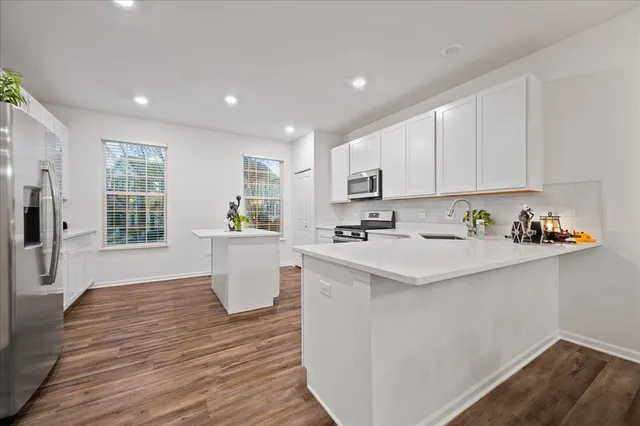 a kitchen with a sink and wooden floor