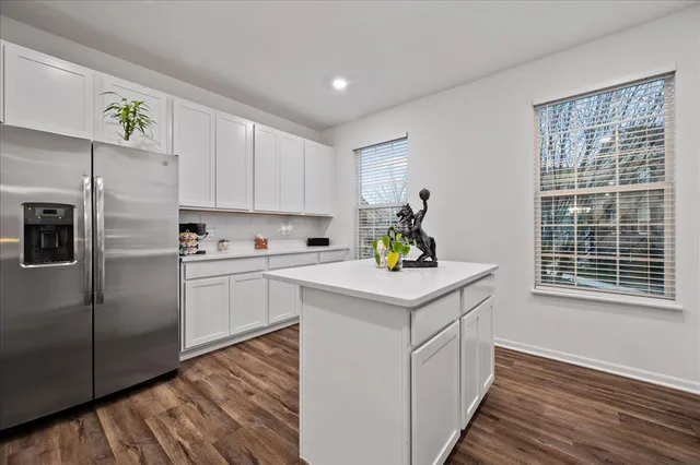 a kitchen with a refrigerator sink and white cabinets