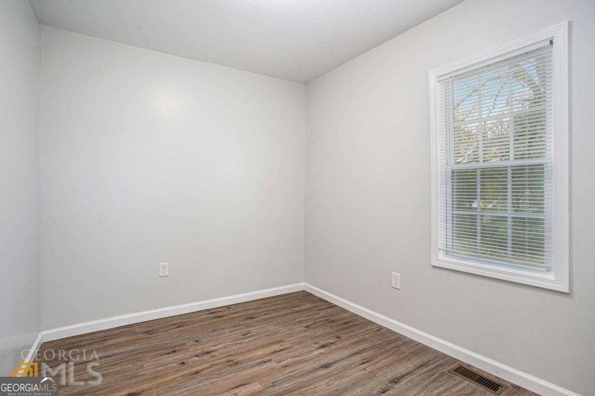 6236 Front Street Douglasville, GA 30134 - Photo 15 of 30 a view of an empty room with wooden floor and a window