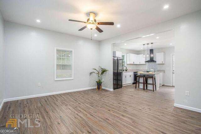 6236 Front Street Douglasville, GA 30134 - Photo 7 of 30 a view of a kitchen with wooden floor and a ceiling fan