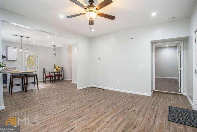 6236 Front Street Douglasville, GA 30134 - Photo 8 of 30 an empty room with wooden floor and way to kitchen