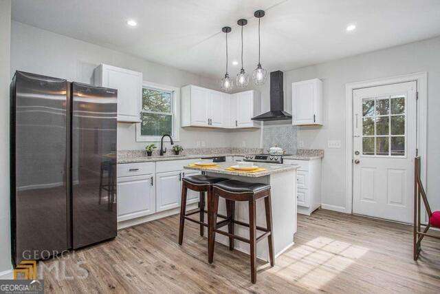 6236 Front Street Douglasville, GA 30134 - Photo 9 of 30 a kitchen with stainless steel appliances granite countertop a refrigerator a sink dishwasher a stove and white cabinets with wooden floor