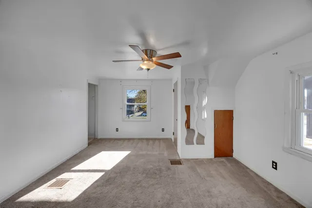 an empty room with windows and closet