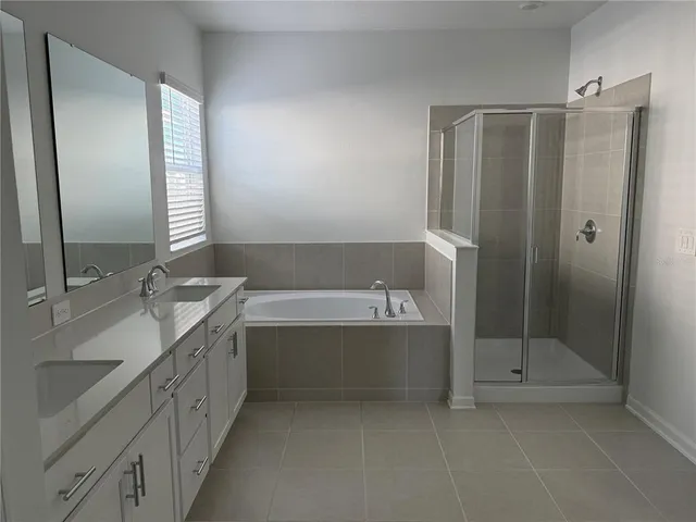 a bathroom with a tub sink shower and mirror