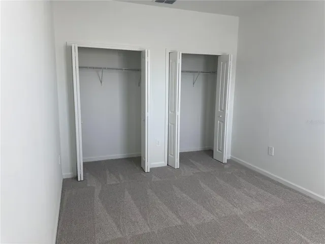 an empty room with closet and a bathroom