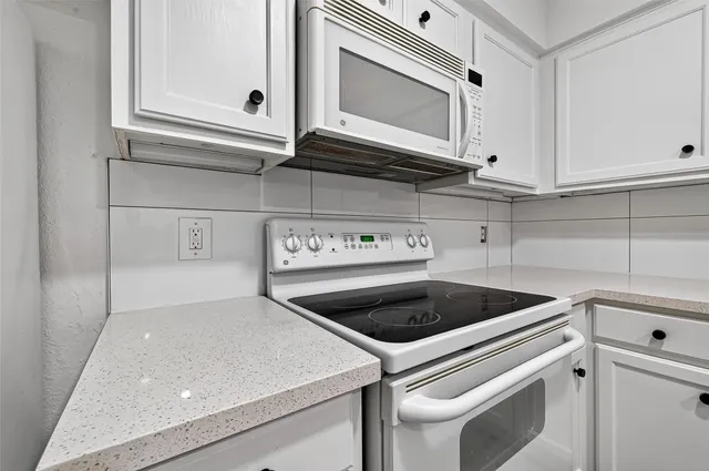 an empty room with wooden floor and ceiling fan