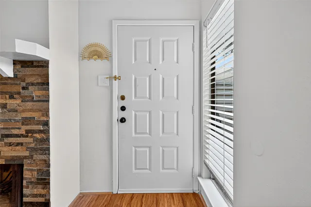 an empty room with wooden floor fireplace and windows