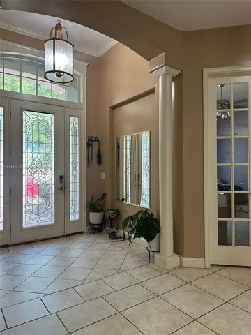 a view of a hallway with windows and chandelier