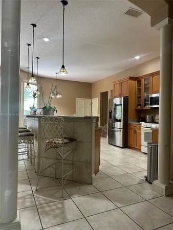 a kitchen with stainless steel appliances granite countertop a refrigerator and a stove top oven
