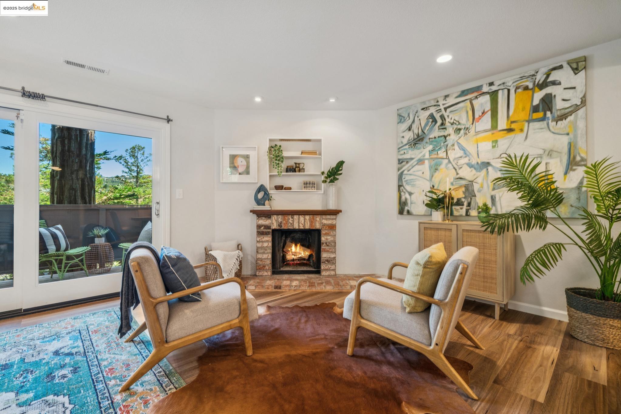 Sitting room with recessed lighting, a lit fireplace, and wood finished floors