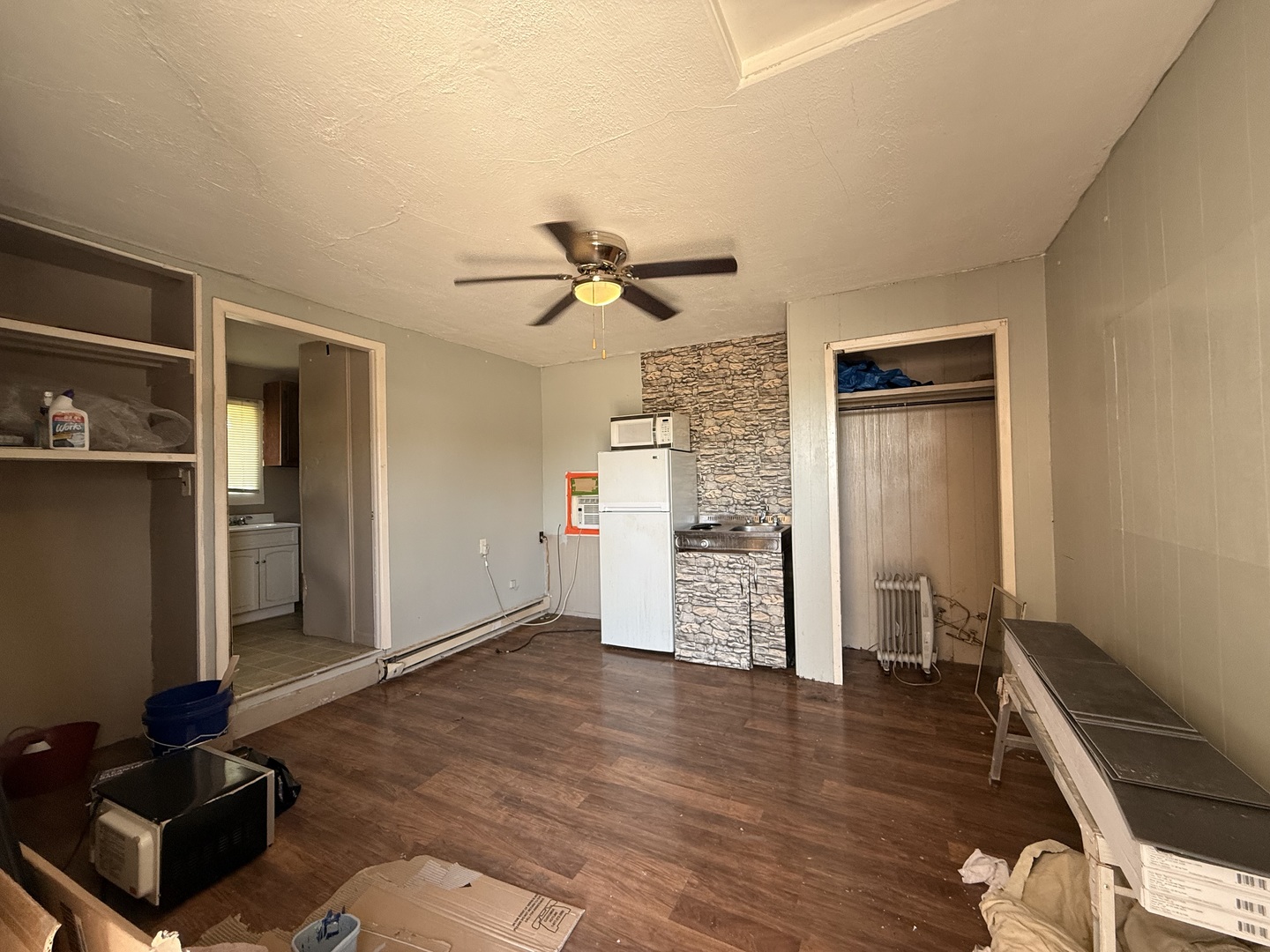 901 Highway 10 Clinton, IL 61727 - Photo 9 of 16 a view of a livingroom with wooden floor and a ceiling fan