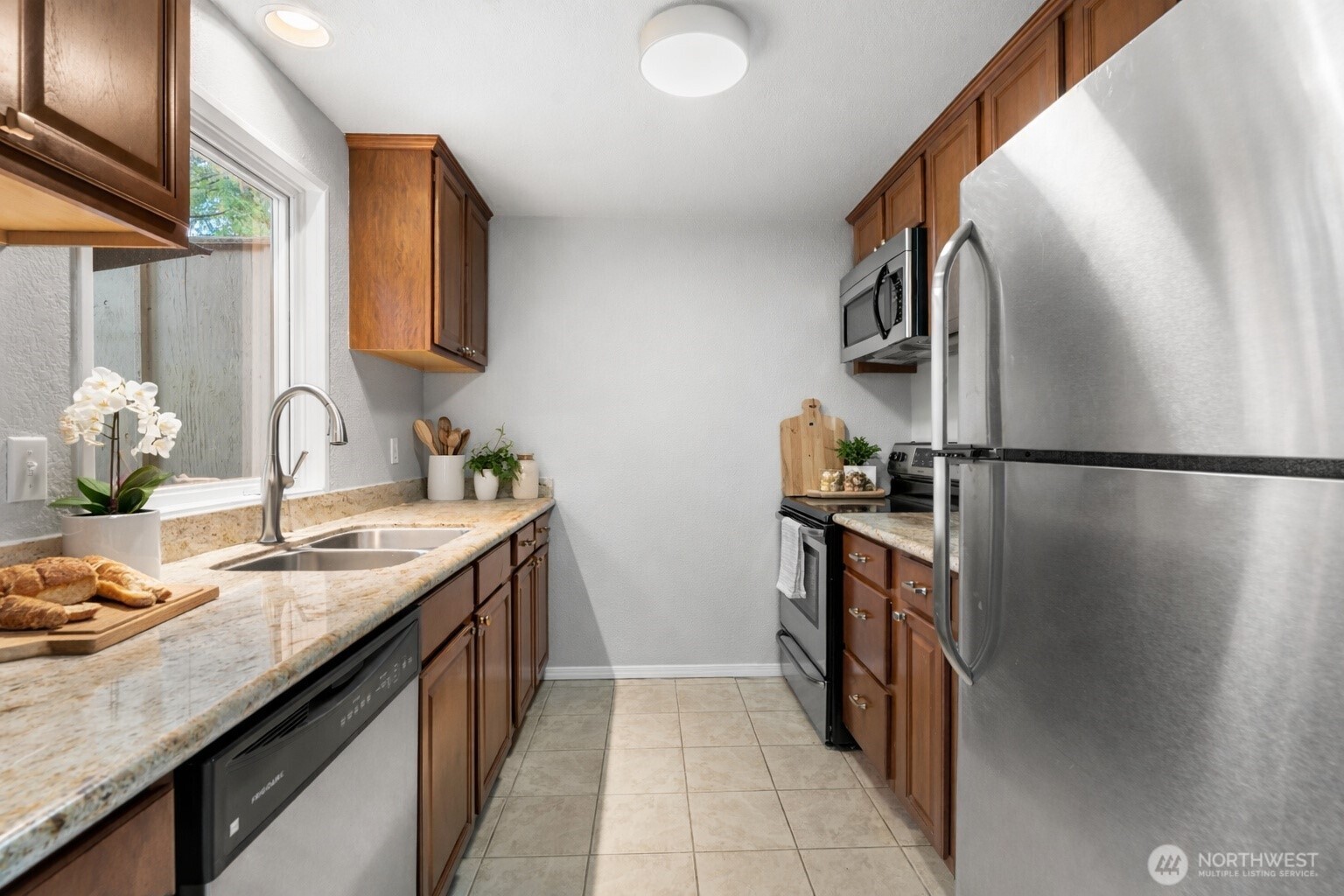 17303 Spanaway Loop Road South, Unit 2 Spanaway, WA 98387 - Photo 8 of 25 a kitchen with stainless steel appliances granite countertop a sink stove and refrigerator
