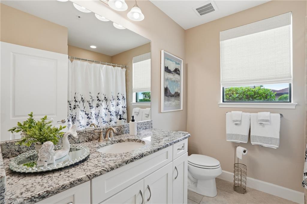9426 Benvenuto Court, Unit 2104 Naples, FL 34119 - Photo 23 of 45 a bathroom with a granite countertop sink and a mirror