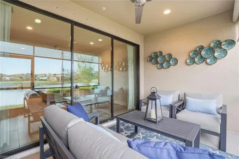 a living room with patio furniture and a floor to ceiling window
