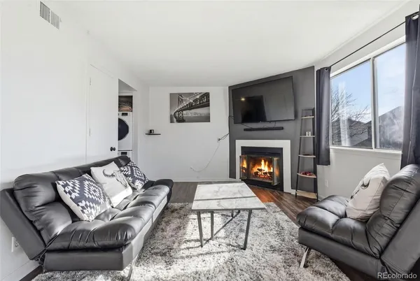 a living room with furniture a flat screen tv and a fireplace