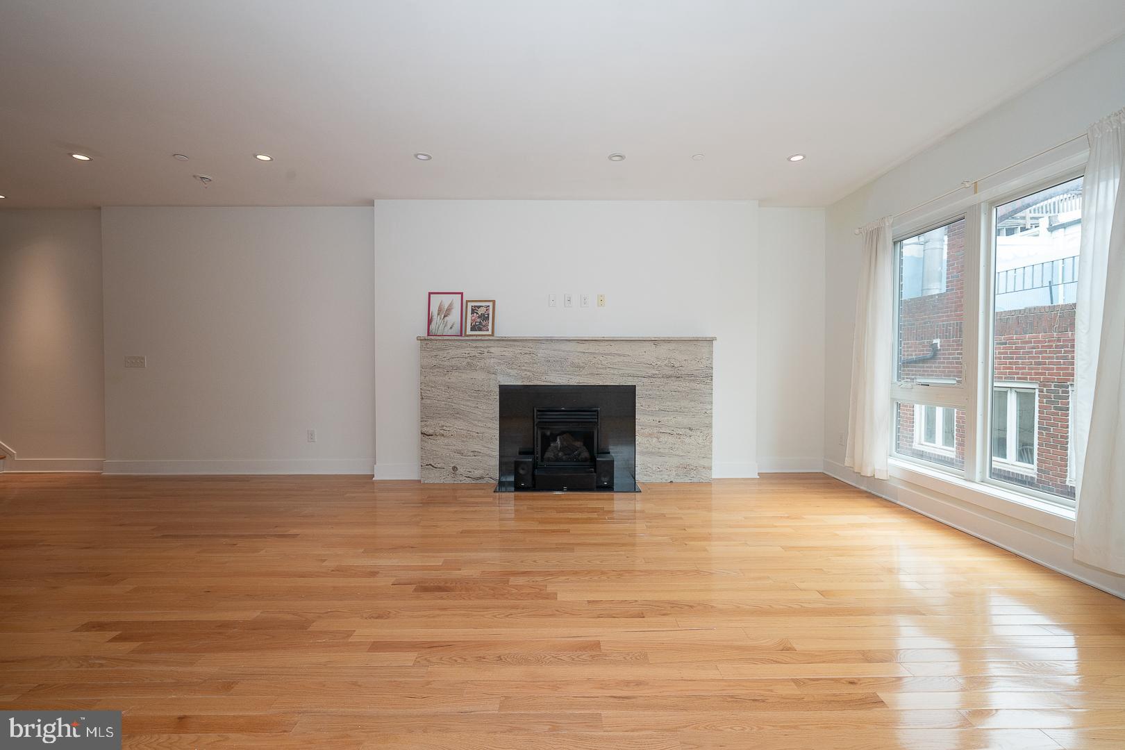 110 Naudain Street, Unit 4 Philadelphia, PA 19147 - Photo 14 of 45 a view of an empty room with a fireplace and a window